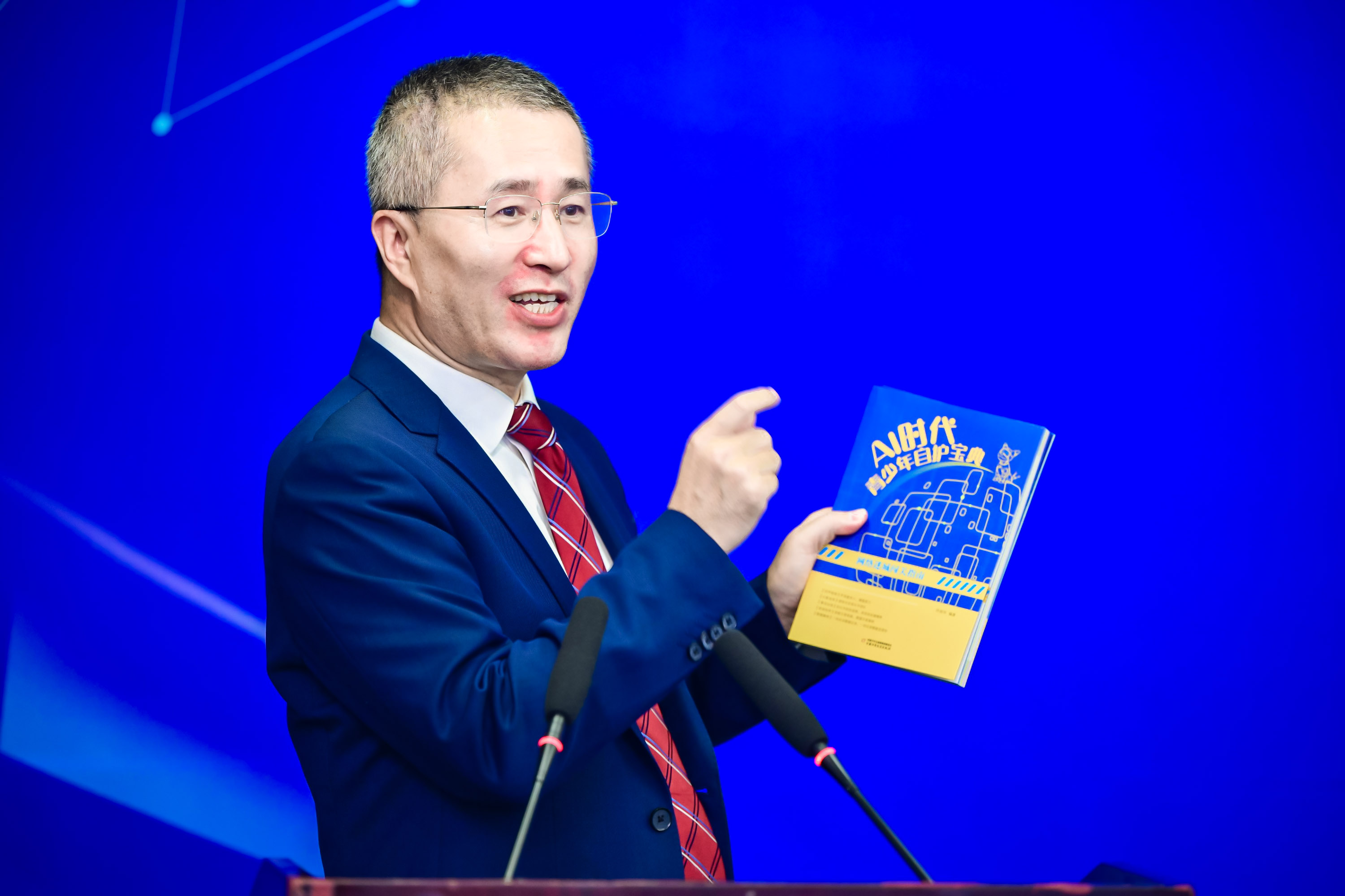 作者佟丽华向与会嘉宾介绍《AI时代青少年自护宝典》套书.jpg